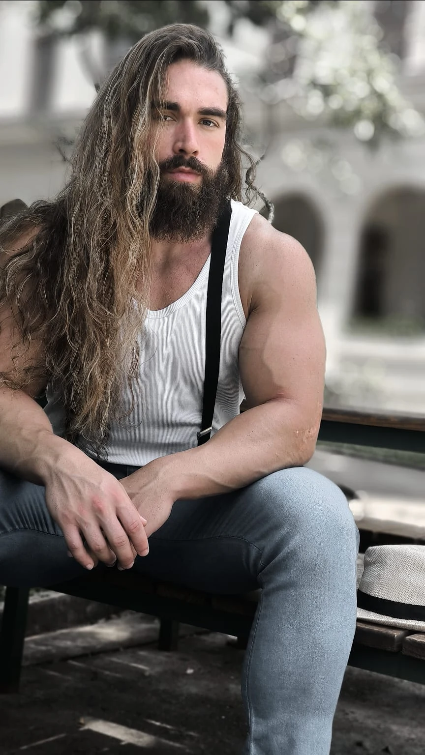 Aron Girardelli em retrato de bodybuilding com regata branca e suspensórios