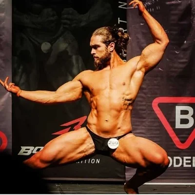 Aron Girardelli em pose dinâmica durante competição de bodybuilding